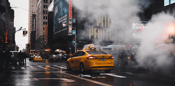 New York Taxi driving down 7th Avenue through a cloud of steam